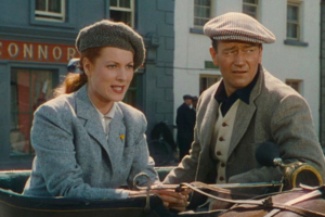 Maureen O'Hara and John Wayne riding a bicycle through a village in Connemara in The Quiet Man